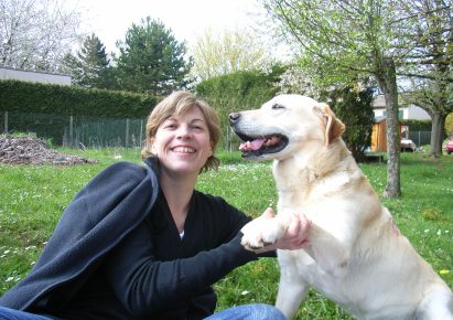 photo d'une femme et d'un chien labrador blanc qui lui donne la patte